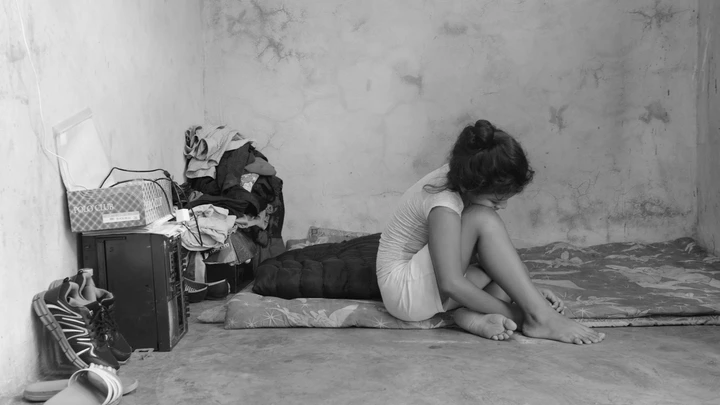 Migrante de 10 anos, que fugiu de ameaças de gangues de El Salvador, senta-se sobre os lençóis que sua família usa como cama em uma casa alugada em Tapachula, Chiapas. Migrante de 10 anos, que fugiu de ameaças de gangues de El Salvador, senta-se sobre os lençóis que sua família usa como cama em uma casa alugada em Tapachula, Chiapas.
