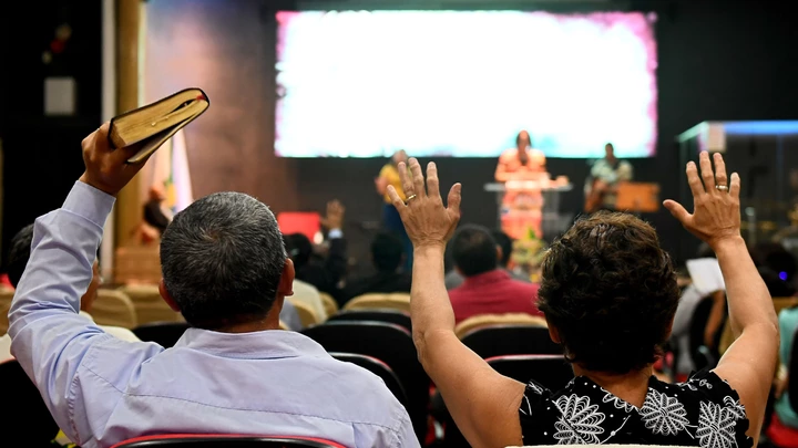 Faithful pray at an evangelical church in Brasilia, on September 21, 2018 for the recovery of the health of Brazilian right-wing presidential candidate Jair Bolsonaro, who suffered a knife attack during the campaign. - The powerful evangelical churches of Brazil are increasingly permeable to the rhetoric of the Brazilian right-wing presidential candidate Jair Bolsonaro. In the latest poll taken by Datafolha, Bolsonaro led with 28 percent ahead of leftist candidate Fernando Haddad on 16. Harvesting 36% of adhesions among evangelical voters, more than twice that of any of the other candidates (Fernando Haddad, 12%; Geraldo Alckmin, 10%, Ciro Gomes, 10%, Marina Silva, 8%). (Photo by EVARISTO SA / AFP)        (Photo credit should read EVARISTO SA/AFP via Getty Images)