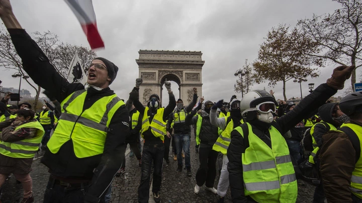 Manifestantes conhecidos como "coletes amarelos" protestam em frente ao Arco do Triunfo, em Paris.