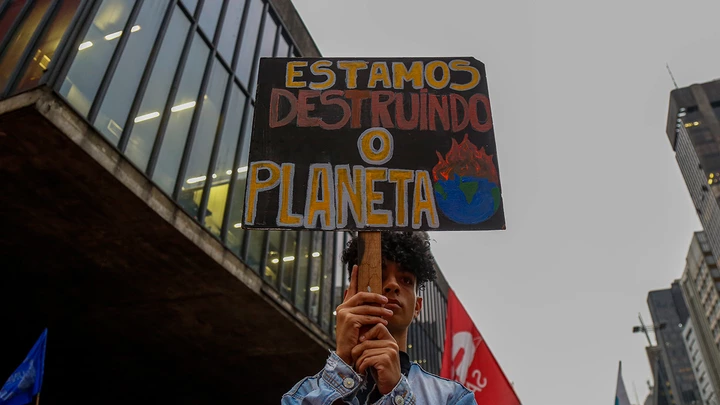A man holds a sing that reads "We are destroying the planet" during a protest along Paulista Avenue in Sao Paulo, Brazil, on September 20, 2019, in the framework of the "Friday for the planet" global demo against climate change.