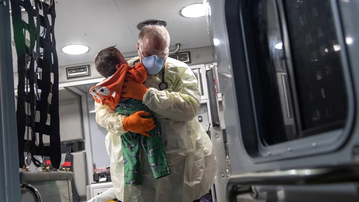 Paramédico segura bebê com febre após chegar de ambulância no hospital de Stamford, em 4 de abril. Paramédico segura bebê com febre após chegar de ambulância no hospital de Stamford, em 4 de abril.