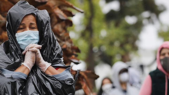 Juana Gomez, à esquerda, usa máscara, luvas, e um saco de lixo para se proteger da chuva na fila de espera em um centro de distribuição de alimentos durante a pandemia do coronavírus, no dia 9 de abril de 2020, em Van Nuys, na Califórnia. Juana Gomez, à esquerda, usa máscara, luvas, e um saco de lixo para se proteger da chuva na fila de espera em um centro de distribuição de alimentos durante a pandemia do coronavírus, no dia 9 de abril de 2020, em Van Nuys, na Califórnia.