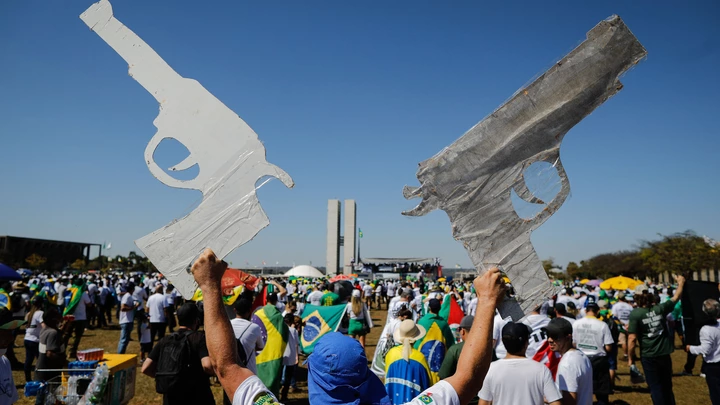 TOPSHOT - A man holds two signals in the shape of a gun during a pro-gun demonstration in support of Brazilian President Jair Bolsonaro in Brasilia, on July 9, 2021. (Photo by Sergio Lima / AFP) (Photo by SERGIO LIMA/AFP via Getty Images)