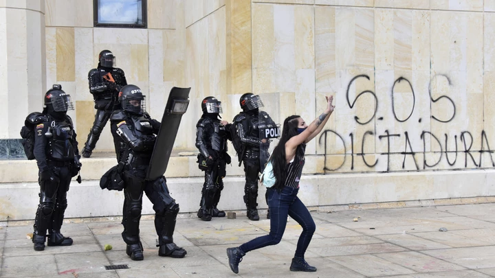 BOGOTA, COLOMBIA - SEPTEMBER 21: A woman asks the protesters who throw stones at the riot police to calm down during protests on International Peace Day on September 21, 2020 in Bogota, Colombia. Demonstrators protest against the recent events of police brutality and mass killings of youngsters and social and indigenous leaders. Worker unions and social organizations also demand government to take emergency actions to control economic crisis. (Photo by Guillermo Legaria/Getty Images) BOGOTA, COLOMBIA - SEPTEMBER 21: A woman asks the protesters who throw stones at the riot police to calm down during protests on International Peace Day on September 21, 2020 in Bogota, Colombia. Demonstrators protest against the recent events of police brutality and mass killings of youngsters and social and indigenous leaders. Worker unions and social organizations also demand government to take emergency actions to control economic crisis. (Photo by Guillermo Legaria/Getty Images)