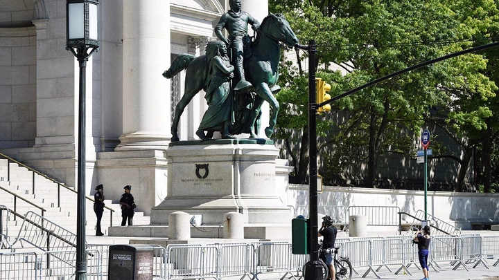 Pessoas passam pela estátua equestre de Theodore Roosevelt em frente ao Museu Americano de História Natural, em 22 de junho, na cidade de Nova York.