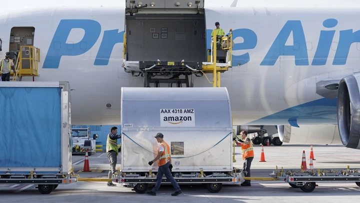 Trabalhadores colocam carga em uma aeronave Amazon Prime Air no Air Hub da empresa no Aeroporto Internacional de Cincinnati, no estado americano de Kentucky, em 11 de outubro de 2021. Trabalhadores colocam carga em uma aeronave Amazon Prime Air no Air Hub da empresa no Aeroporto Internacional de Cincinnati, no estado americano de Kentucky, em 11 de outubro de 2021.