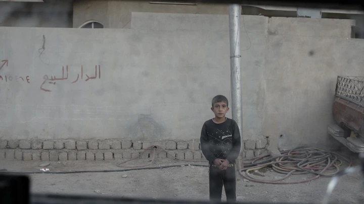 A young boy stares at the photographer through the window of an Iraqi army Humvee in the Karkukli neighborhood of Mosul, Iraq on Nov. 17, 2016. A young boy stares at the photographer through the window of an Iraqi army Humvee in the Karkukli neighborhood of Mosul, Iraq on Nov. 17, 2016.