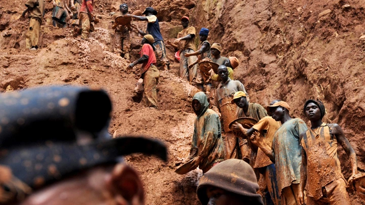 (FILES) This photo taken February 23, 2009 shows mining workers standing on a muddy cliff as they work at a gold mine in Chudja, near Bunia, north eastern Congo. Eighteen prospectors were killed overnight on August 19-20, 2009 in a diamond mine in central Democratic Republic of Congo, union officials said on August 20, 2009. Celestin Kubela, the head of the local mining authority in Kasai province, said that the victims, who were all illlegal miners, are thought to have touched a power cable deep underground. AFP PHOTO / LIONEL HEALING (Photo credit should read LIONEL HEALING/AFP/Getty Images)