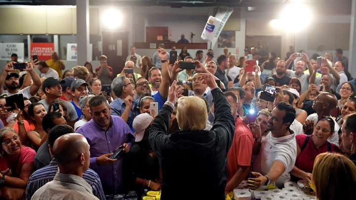 US President Donald Trump takes part in a food and suplly distribution at the Cavalry Chapel in Guaynabo, Puerto Rico on October 3, 2017.Nearly two weeks after Hurricane Maria thrashed through the US territory, much of the islands remains short of food and without access to power or drinking water. / AFP PHOTO / MANDEL NGAN (Photo credit should read MANDEL NGAN/AFP/Getty Images)