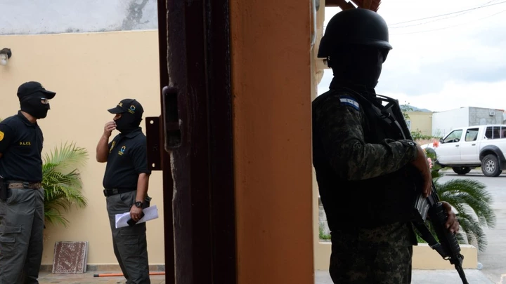 ntegrantes da Direção de Luta contra o Narcotráfico de Honduras (DLCN) e agentes das Forças Armadas participam de operação de apreensão de 32 imóveis, 15 veículos e nove empresas comerciais de seis oficiais de polícia hondurenhos acusados de participar de esquema de tráfico de drogas (Orlando Sierra/AFP/Getty Images)