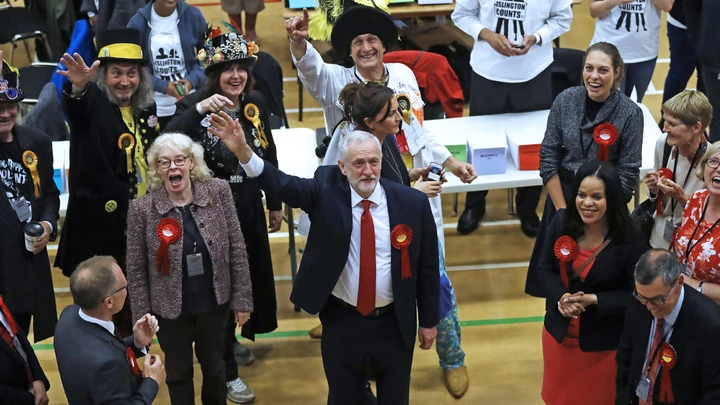Britain's Labour party leader Jeremy Corbyn, bottom center, waves after arriving for the declaration at his constituency in London, Friday, June 9, 2017. Britain voted Thursday in an election that started out as an attempt by Prime Minister Theresa May to increase her party's majority in Parliament ahead of Brexit negotiations but was upended by terror attacks in Manchester and London during the campaign's closing days. (AP Photo/Frank Augstein)