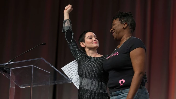 US actress Rose McGowan and Founder of #MeToo Campaign Tarana Burke, embrace on stage at the Women's March / Women's Convention in Detroit, Michigan, on October 27, 2017. A stream of actress including Rose McGowan, models and ex-employees have come out, many anonymously, to accuse Hollywood producer Harvey Weinstein of sexual harassment and abuse dating as far back as the 1990s. / AFP PHOTO / RENA LAVERTY (Photo credit should read RENA LAVERTY/AFP/Getty Images)