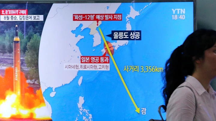 A woman passes by a TV screen showing a local news program reporting on North Korea's threats to strike Guam with missiles at the Seoul Train Station in Seoul, South Korea, Thursday, Aug. 10, 2017. North Korea has announced a detailed plan to launch a salvo of ballistic missiles toward the U.S. Pacific territory of Guam, a major military hub and home to U.S. bombers. If carried out, it would be the North's most provocative missile launch to date. The signs at left top read " North Korea announced a plan to launch a salvo of ballistic missiles toward the Guam. (AP Photo/Ahn Young-Joon)