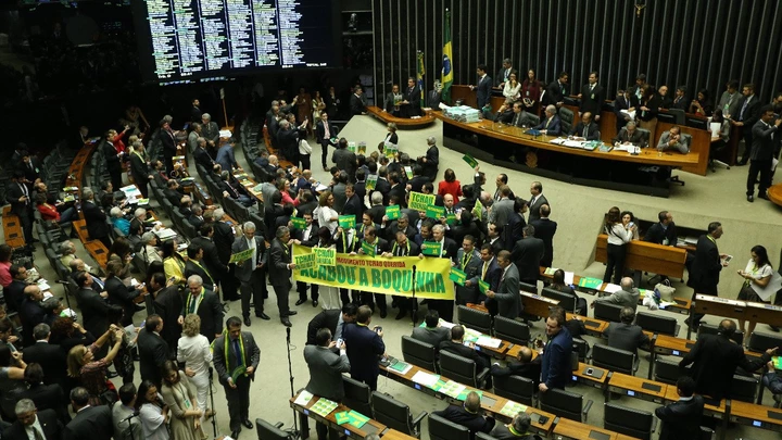 BRASÍLIA, DF, 15.04.2016: DILMA-IMPEACHMENT – Deputados com cartaz “acabou a boquinha” durante debate do processo de impeachment da presidente Dilma Rousseff, na Câmara dos Deputados, nesta sexta-feira (15). (Foto: Alan Marques/Folhapress)