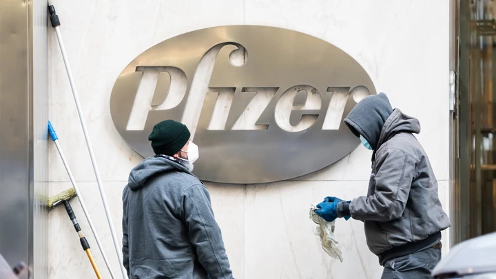 Trabalhadores limpam o logotipo da Pfizer em 21 de dezembro de 2020, em Nova York.