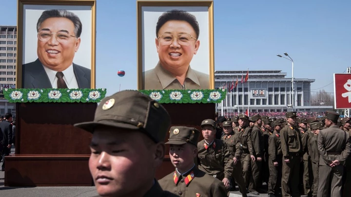 Soldados norte-coreanos passam diante dos retratos dos ex-líderes da Coreia do Norte / AFP PHOTO / Ed JONES (Photo credit should read ED JONES/AFP/Getty Images)
