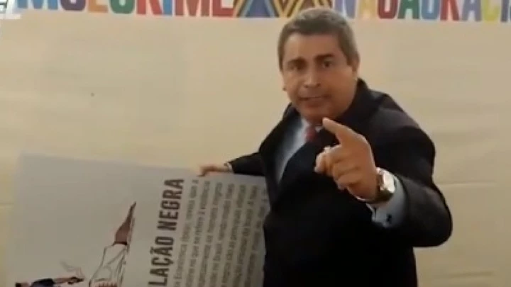 O deputado Coronel Tadeu (PSL) arranca cartaz com charge de Carlos Latuff em trasmissão ao vivo no Twitter.  O deputado Coronel Tadeu (PSL) arranca cartaz com charge de Carlos Latuff em trasmissão ao vivo no Twitter.