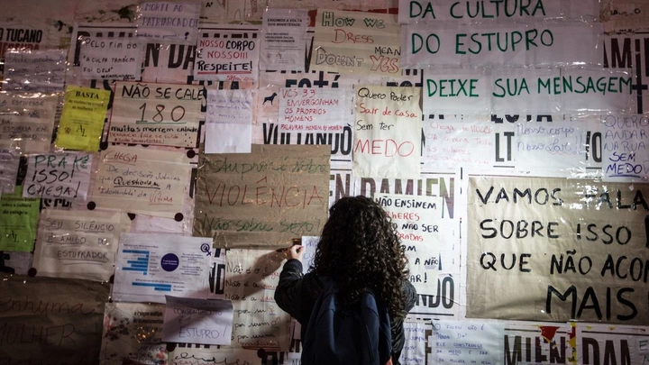 Uma garota cola cartazes contra estupro em tapume no MASP, na avenida Paulista. São Paulo, maio de 2016.