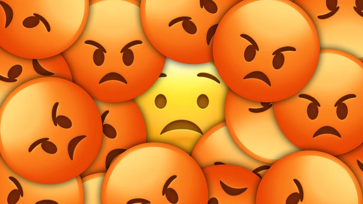 Emojis de carinhas bravas ao redor de um emoji assustado.